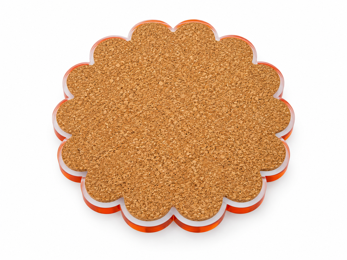 Cork back of a scalloped round coaster with an orange acrylic edge