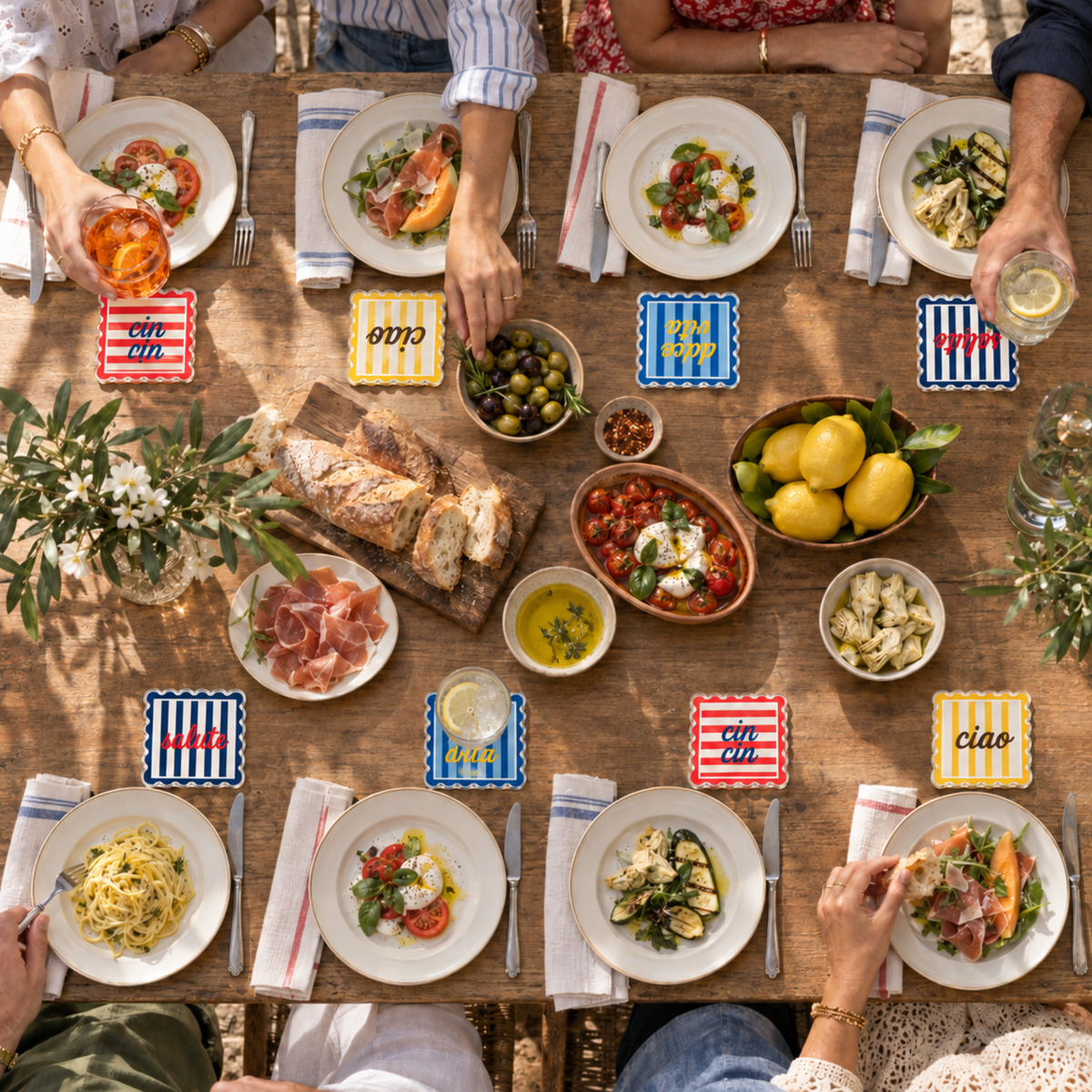 Overhead view of an Italian lunch table set with the striped coasters, pasta and lemons
