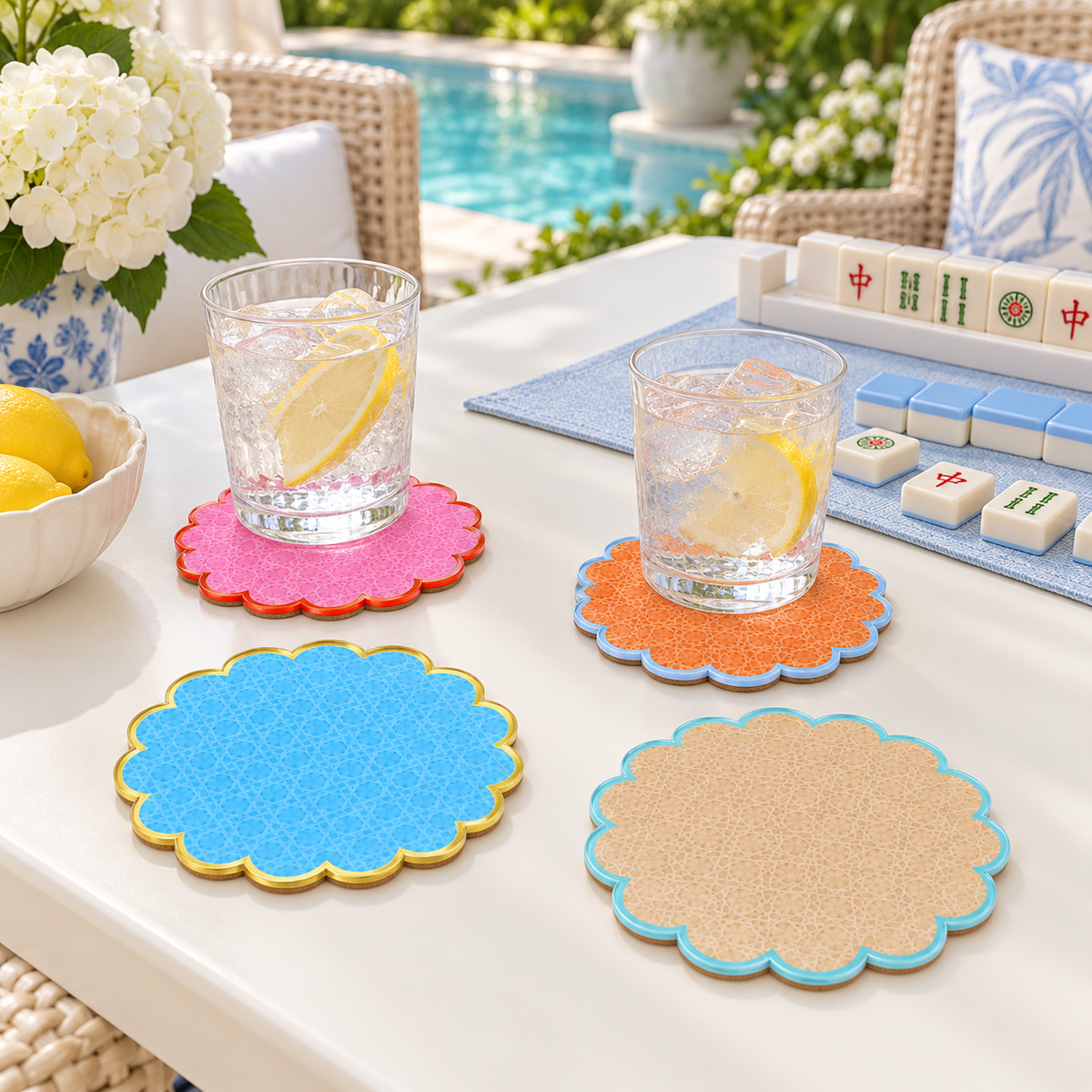 Cabana coasters under glasses of lemon water on a poolside table set for mahjong