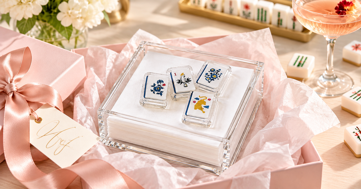 Mahjong 2 acrylic napkin weight on cocktail napkins in a clear acrylic napkin holder, set in a pink gift box