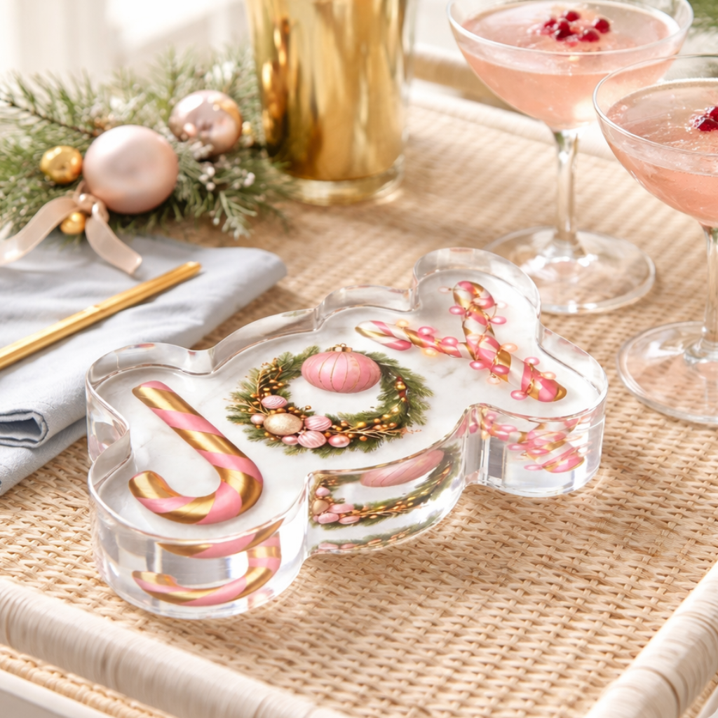 JOY acrylic napkin weight: "JOY" spelled with a pink-and-white candy cane J, a wreath of pink ornaments for the O and a Y made of pink baubles