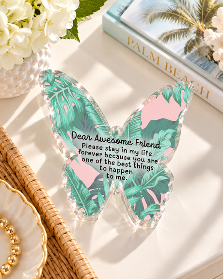 Pink and green palm leaf acrylic butterfly desk weight styled on a tabletop