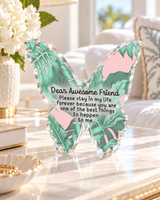 Palm leaf print acrylic butterfly desk weight displayed with books and decor