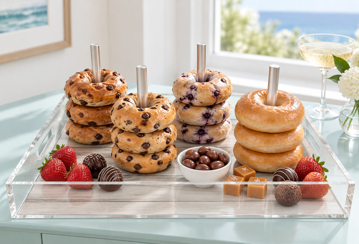 Blueberry bagels and donuts stacked on the dowels with fresh berries on a coastal table