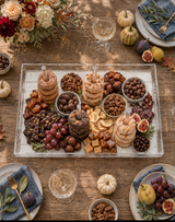 Donut and dessert board from above with chocolates, caramels, nuts, grapes and figs on a fall harvest table