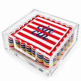 Red striped cin cin coaster on top of the set in a clear acrylic holder, angled view