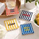 Striped acrylic coasters on a white table with white flowers
