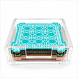 Aqua trellis coaster on top of a stack of four in a clear acrylic holder, front view