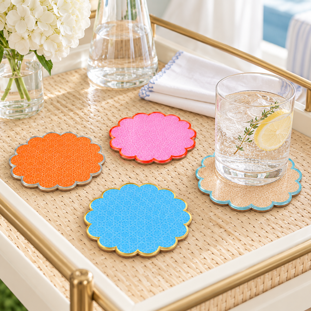 Cabana coasters on a gold tray beside a glass of water with lemon