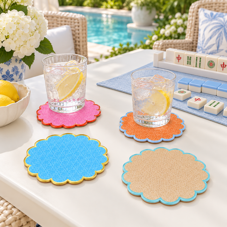 Cabana coasters under glasses of lemon water on a poolside table set for mahjong