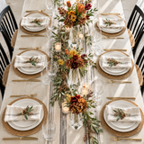 Overhead view of a fall dinner table with clear acrylic bud vases and autumn florals along the runner