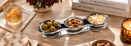 Clear acrylic three-bowl serving set with appetizers and snacks