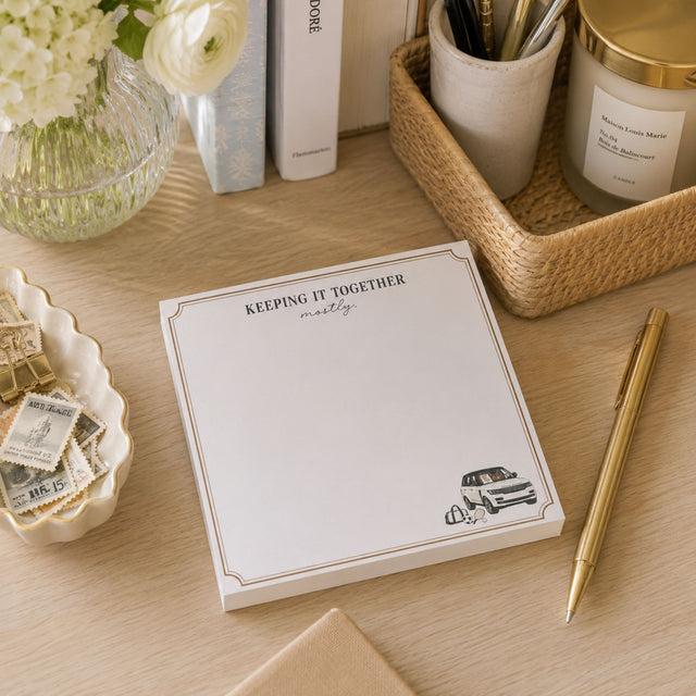 Keeping It Together, Mostly 5x5 notepad with gold border and SUV illustration on a desk
