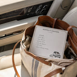 Keeping It Together notepad with a handwritten errands list in a tote bag on a car seat