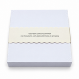 Back of a 5x5 notepad in cello wrap with a scalloped band reading 100 sheets card stock paper, for thoughts, lists and everything in between
