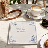 Notes and Goals notepad reading Note to self: breathe, begin, and buy flowers beside a cappuccino