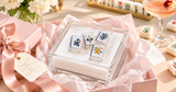Mahjong 2 acrylic napkin weight on cocktail napkins in a clear acrylic napkin holder, set in a pink gift box