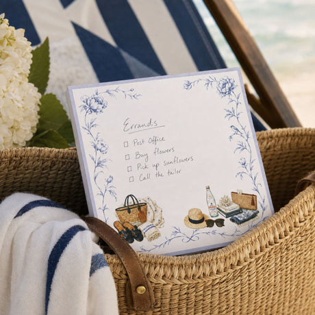 Proper Beach Club notepad on a woven table with coral, blue hydrangeas and a blue and white pen