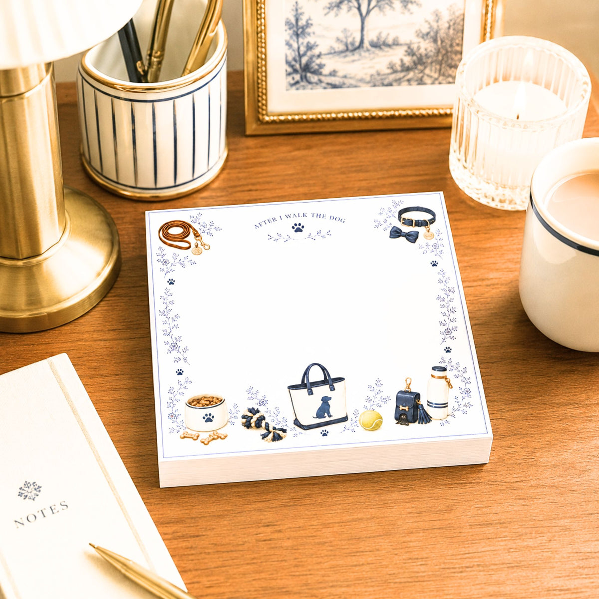 Proper Dogs After I Walk the Dog notepad on a desk with a brass lamp, candle and blue toile print