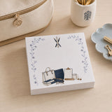 Proper Teacher notepad on a desk with a pen cup and gold binder clips