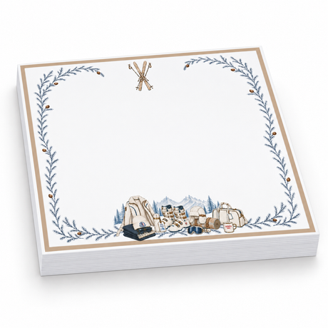 Proper Ski 5x5 notepad with a blank page, crossed skis, a gold border, blue pine vines and ski gear, angled view
