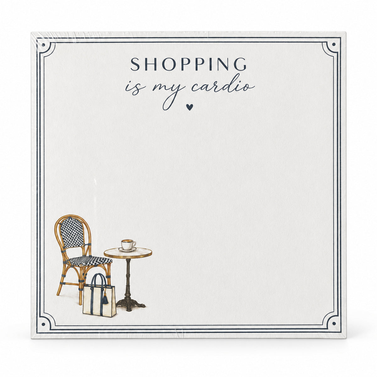 Front view of the Shopping Is My Cardio 5x5 notepad with a cafe chair, bistro table and tote