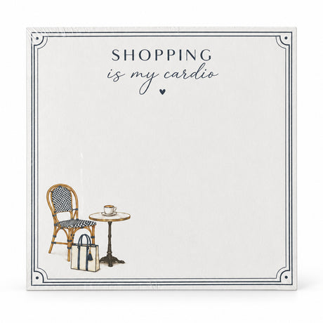Front view of the Shopping Is My Cardio 5x5 notepad with a cafe chair, bistro table and tote