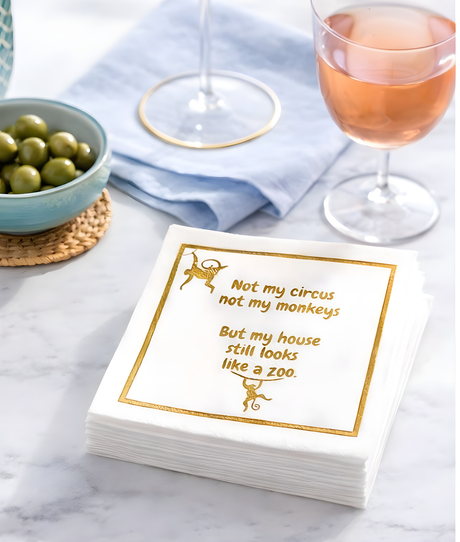 Linen-feel cocktail napkins printed with Not my circus, not my monkeys, but my house still looks like a zoo in gold lettering